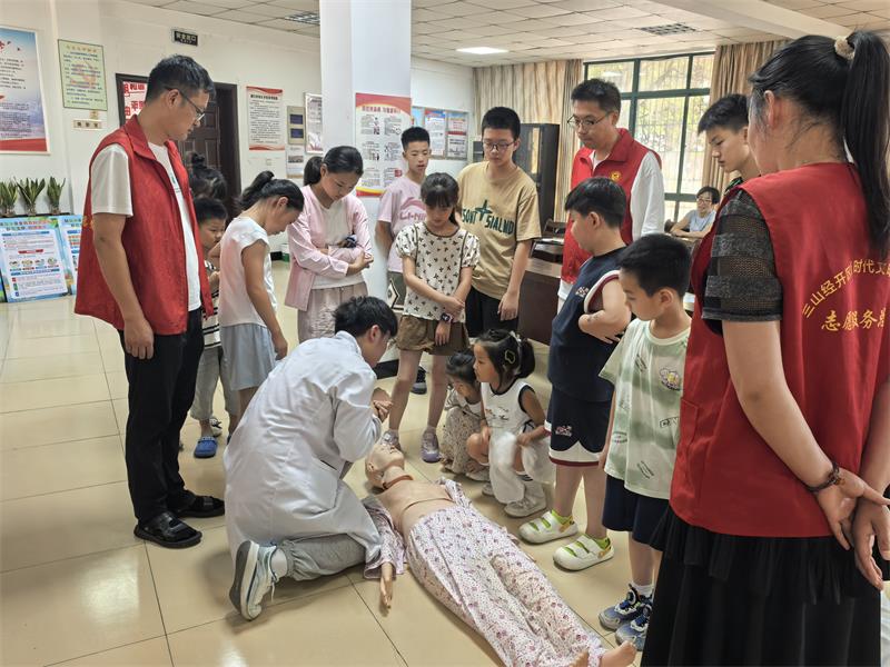 图为卫生院医生为青少年讲解溺水后急救措施