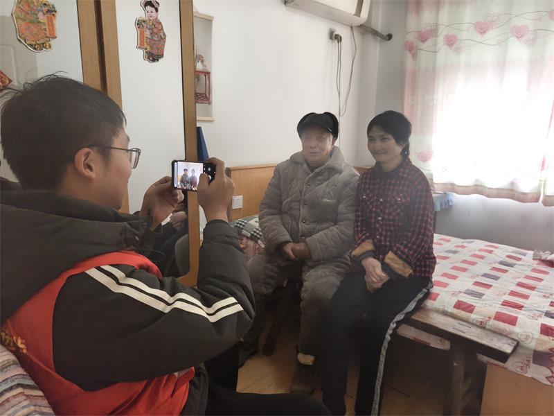 图为志愿者上门为行动不便的老人拍摄全家福