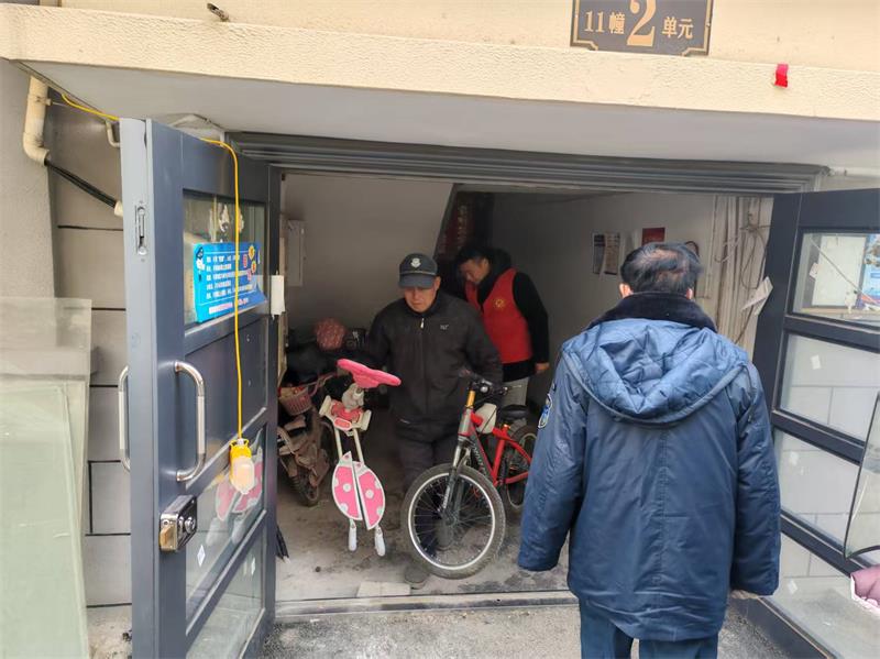 图为志愿者和网格员清理楼道垃圾