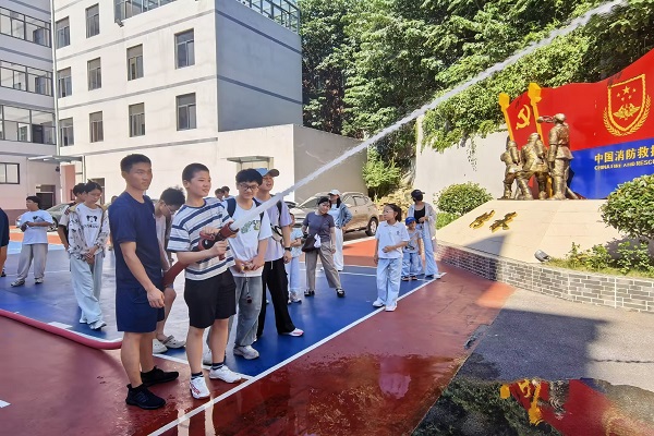 图：孩子们轮流上手操作消防水枪.jpeg