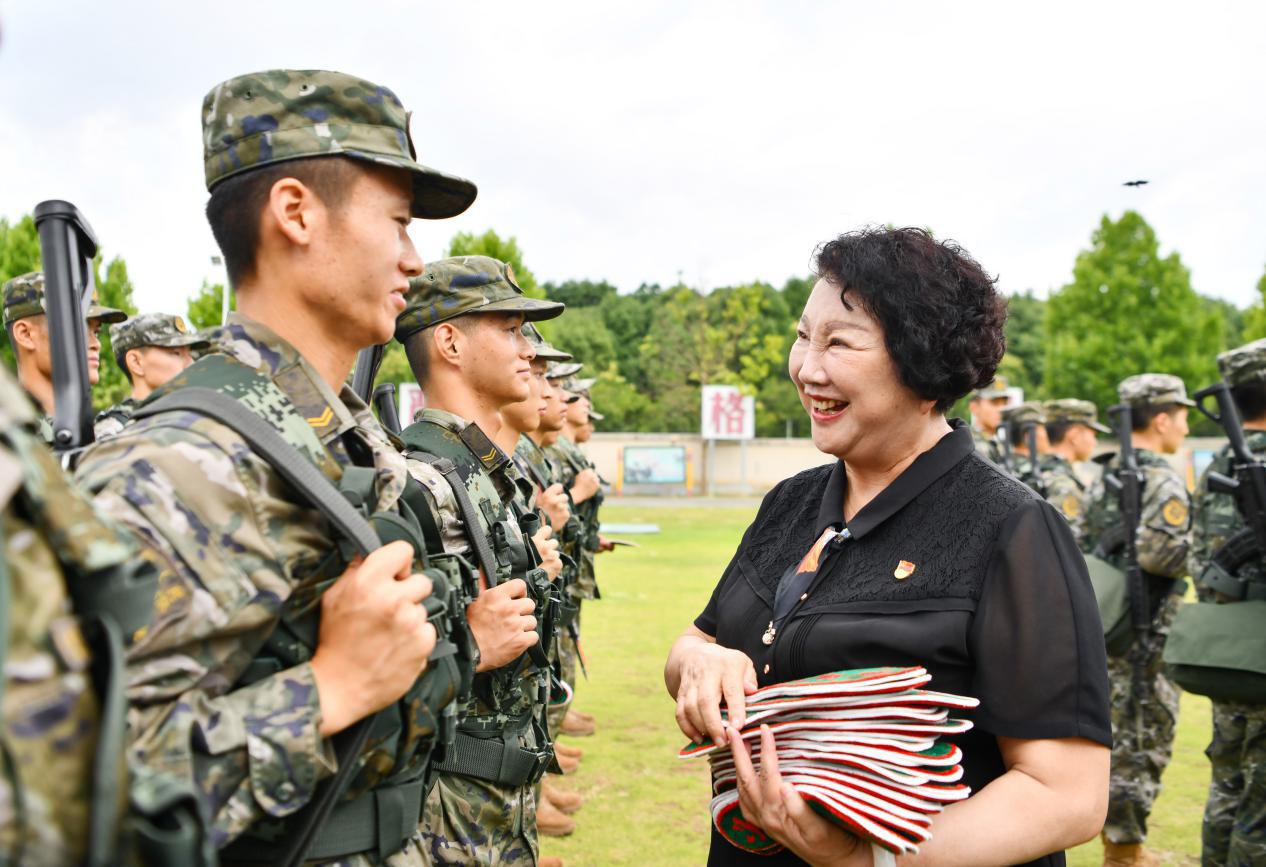 图2：2024年6月21日，安徽合肥，在武警安徽总队合肥支队训练场，“兵妈妈”朱呈镕慰问训练官兵并赠送鞋垫。