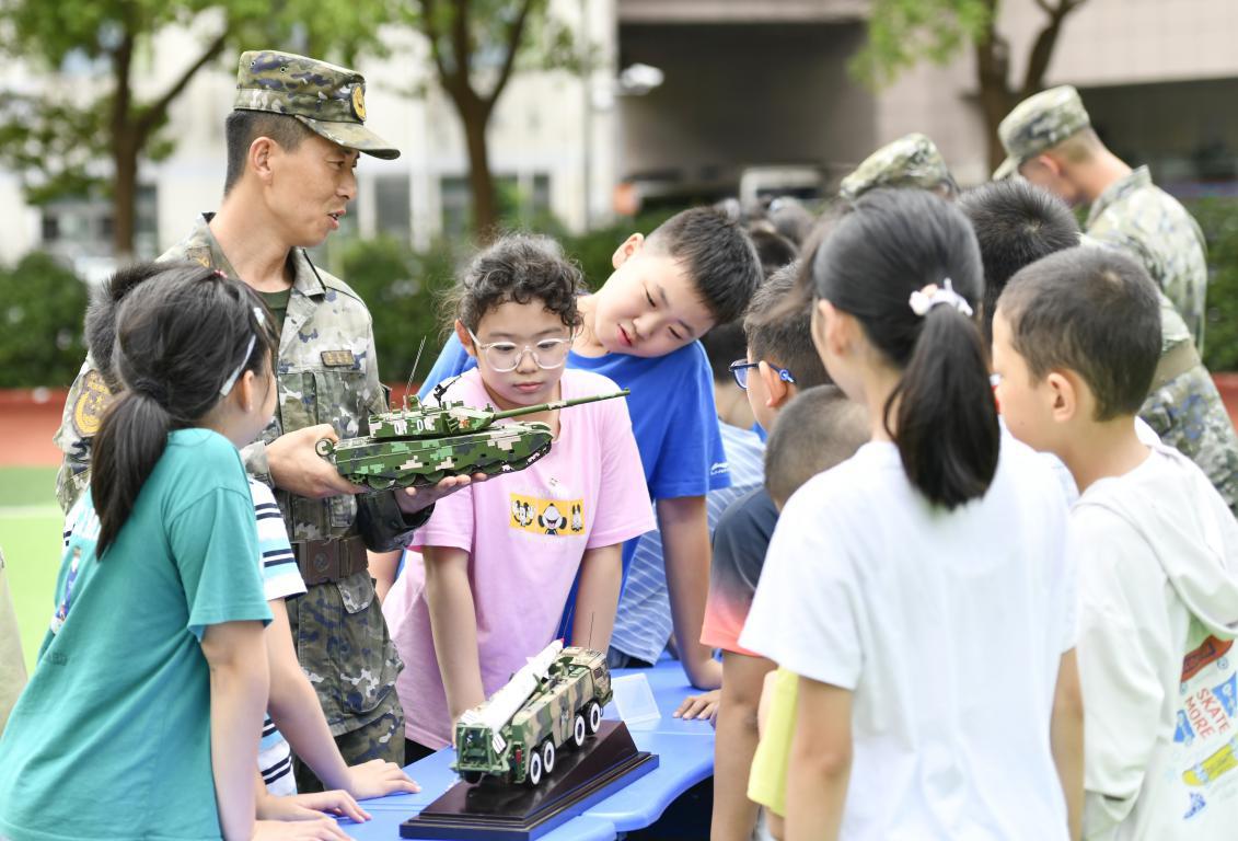 图2：2024年9月19日，安徽合肥，在安徽省合肥市长江路第二小学，武警官兵在向学生介绍装备模型。