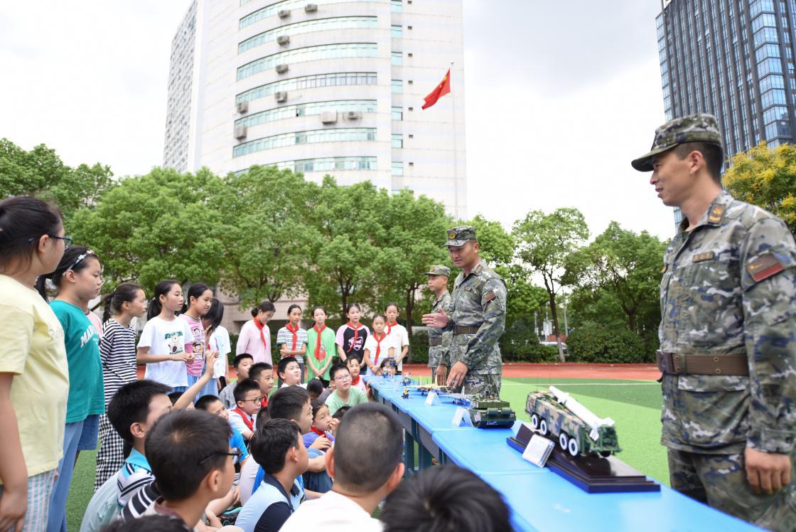 图16：2024年9月19日，安徽合肥，在安徽省合肥市长江路第二小学，武警官兵在向学生介绍装备模型。