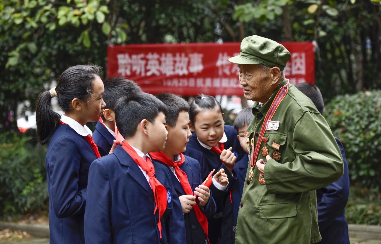 图2：2024年10月19日，安徽合肥，今年89岁抗美援朝老兵杨克美在向孩子们讲述勋章的故事。