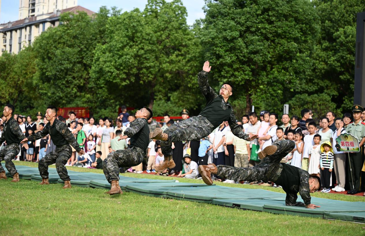 图1：2025年7月30日，安徽合肥，在武警安徽总队某部营区，军嫂军娃们在观看倒功演示。