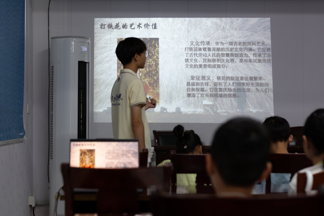 图为学生专心听支教团队成员讲解打铁花艺术价值。.jpg