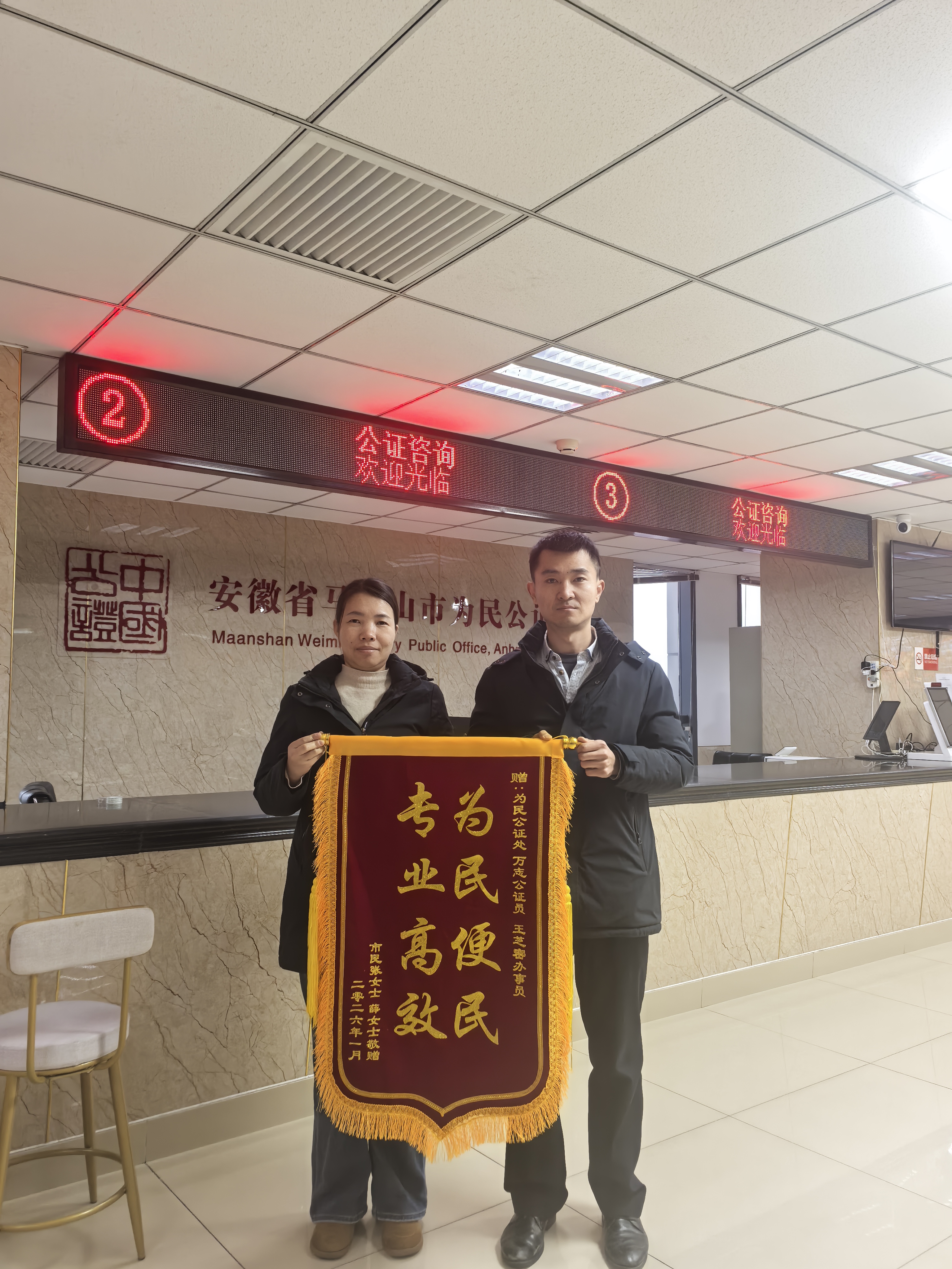 1月26日公证员万志和接待员王芝密收到群众赠送的锦旗.jpg