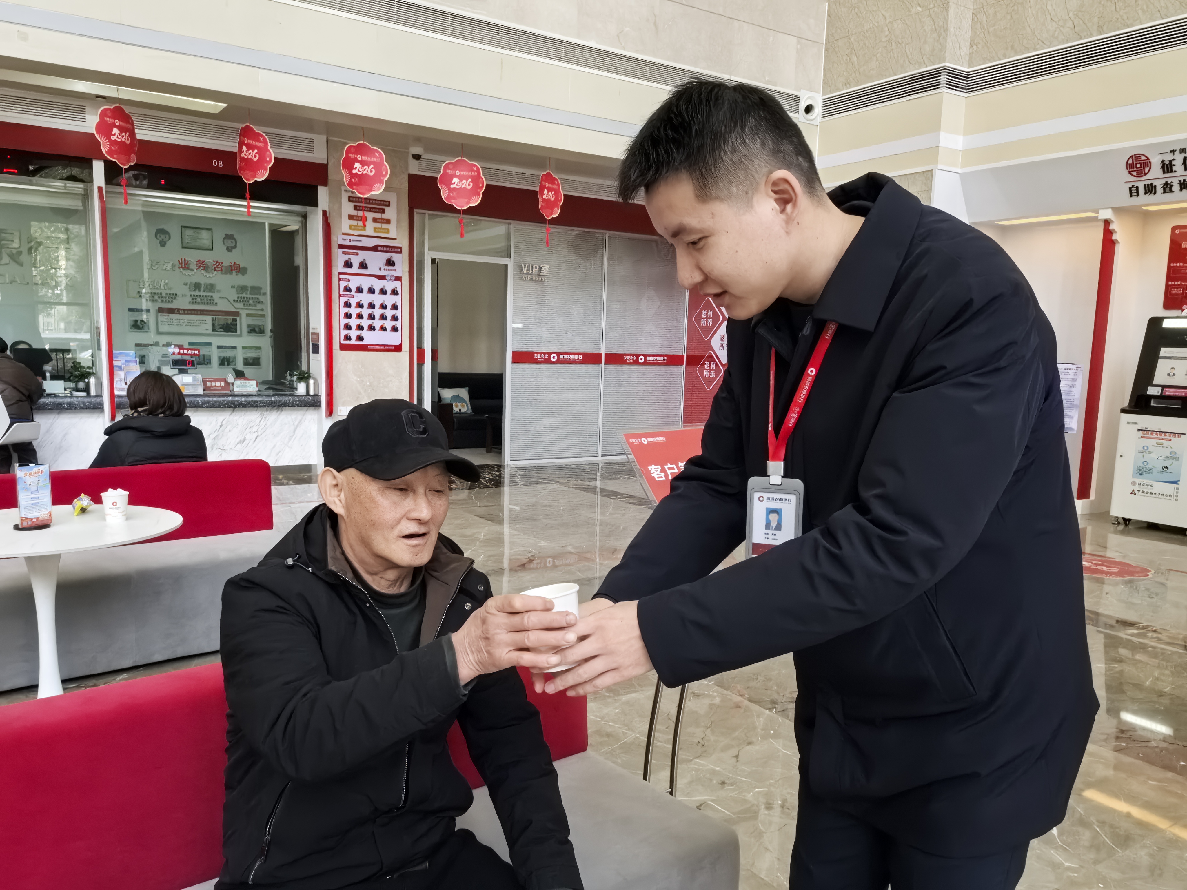 图为营业部员工暖心服务相伴，为等候的客户送上热水。樊茂摄影。.jpg
